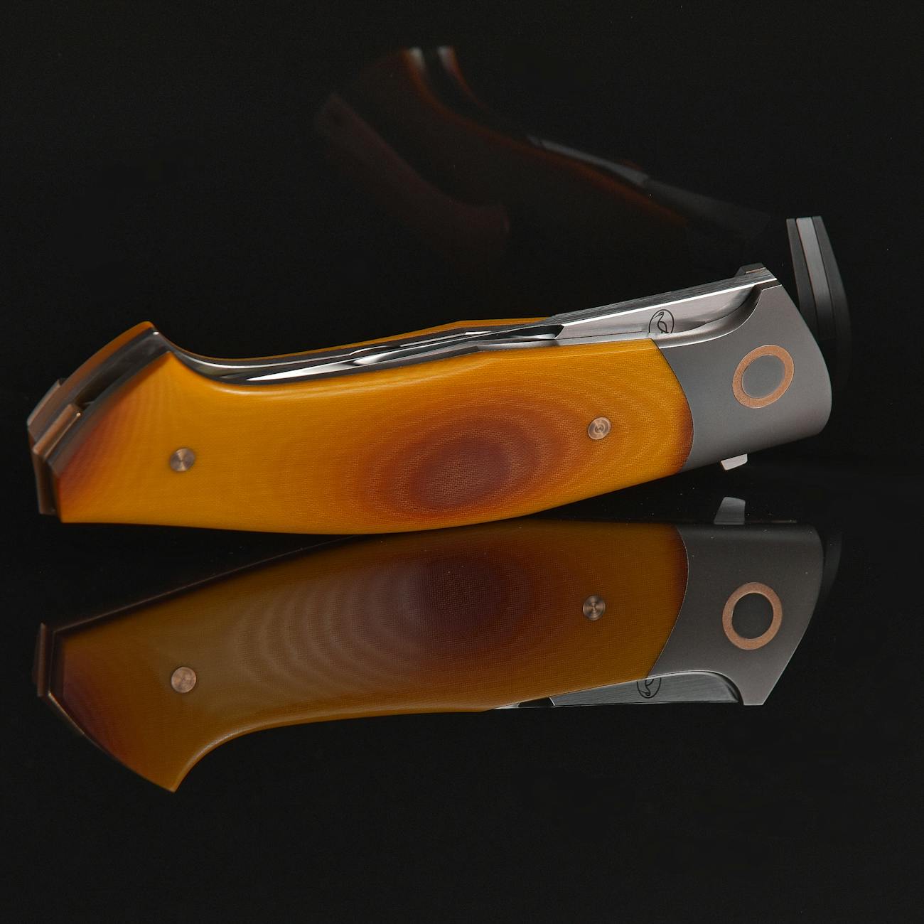 Small folding pocket knife on black reflective surface with negative space, banner for micro OTF buying guide.